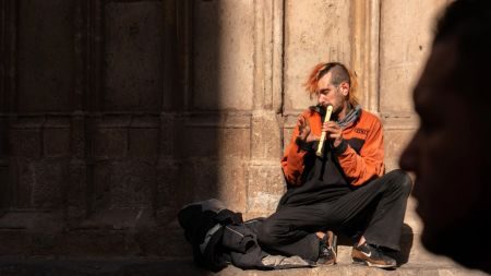 Man in sunlight playing recorder